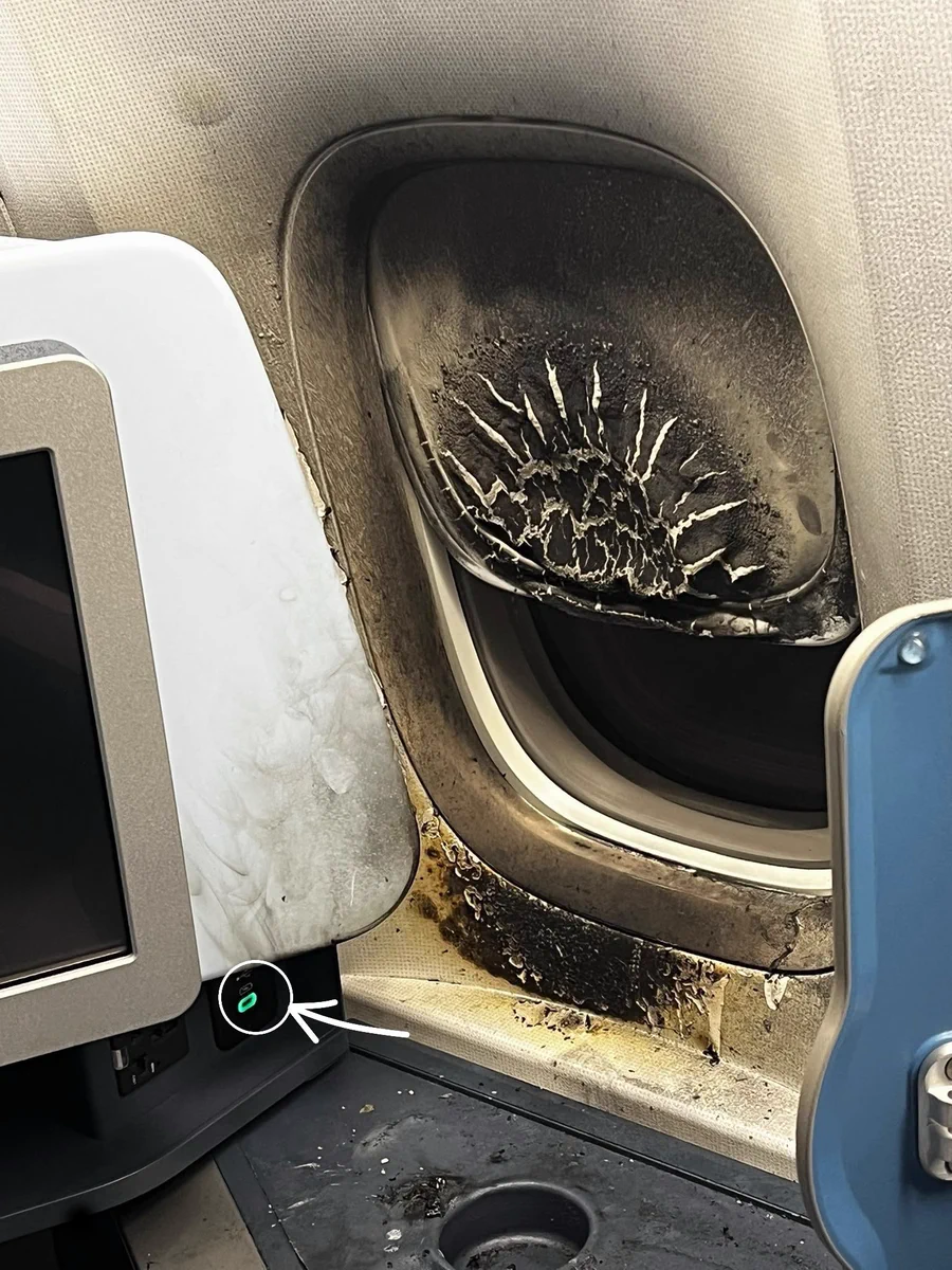 Detalle del puerto de carga USB del asiento de la aeronave.